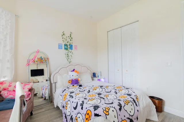 a bedroom with a bed and a wooden floor