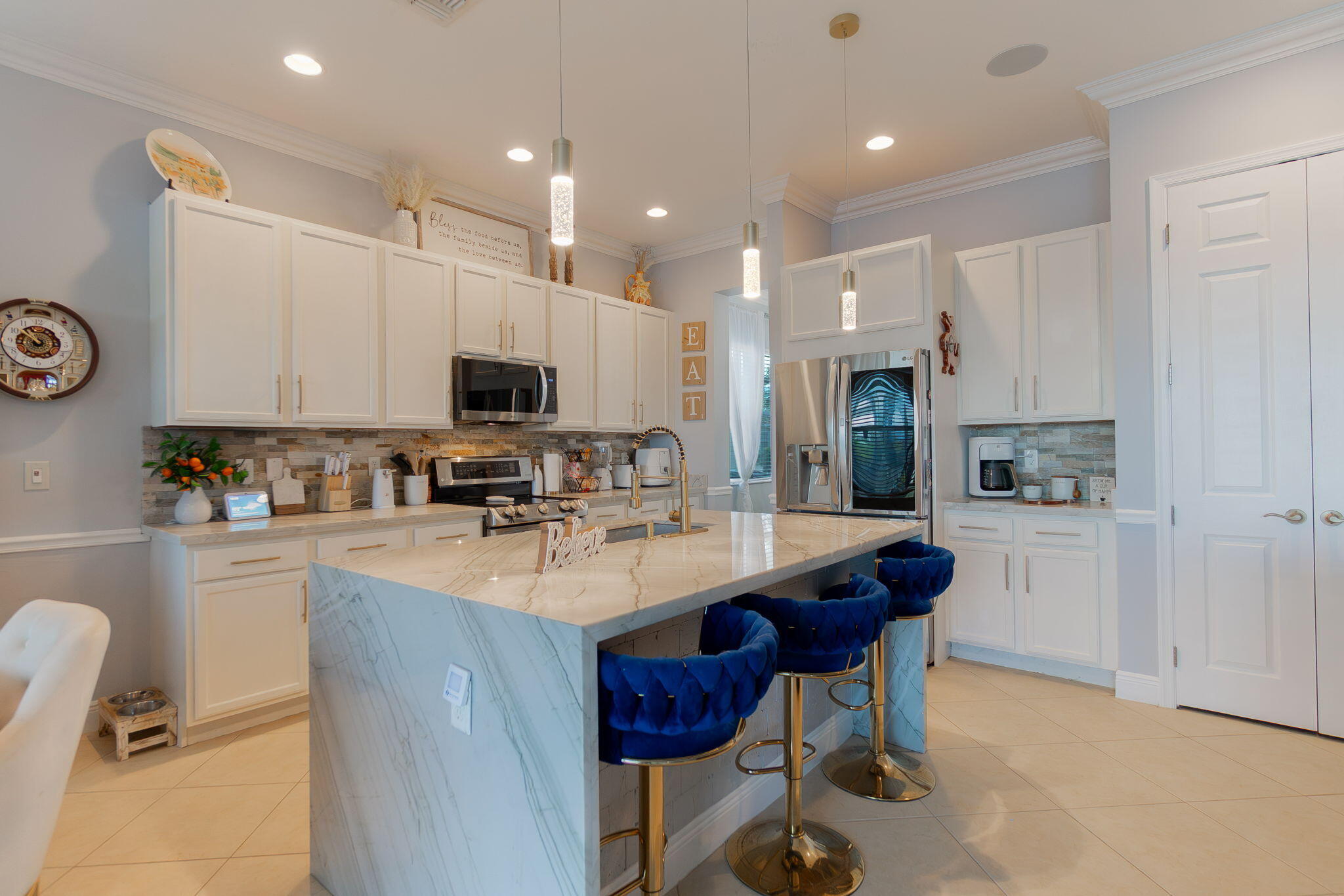 3011 Strada Court Royal Palm Beach, FL 33411 - Photo 19 of 57 a kitchen with stainless steel appliances kitchen island granite countertop a sink and a refrigerator