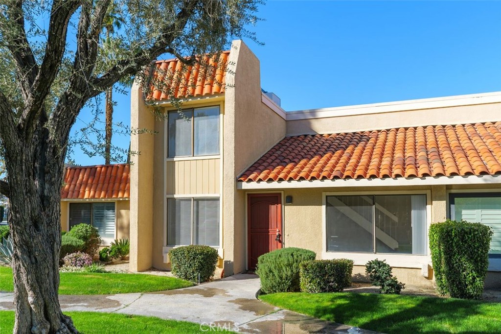 a front view of a house with a garden and plants