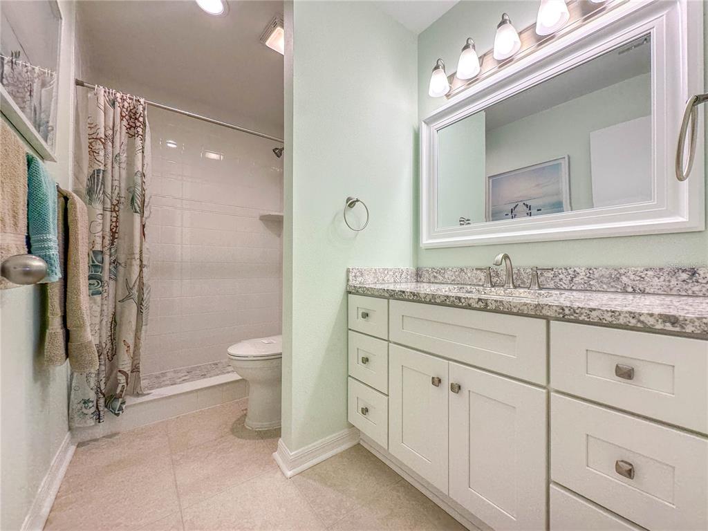 6800 Placida Road, Unit 268 Englewood, FL 34224 - Photo 14 of 33 a bathroom with a granite countertop sink a toilet and a mirror