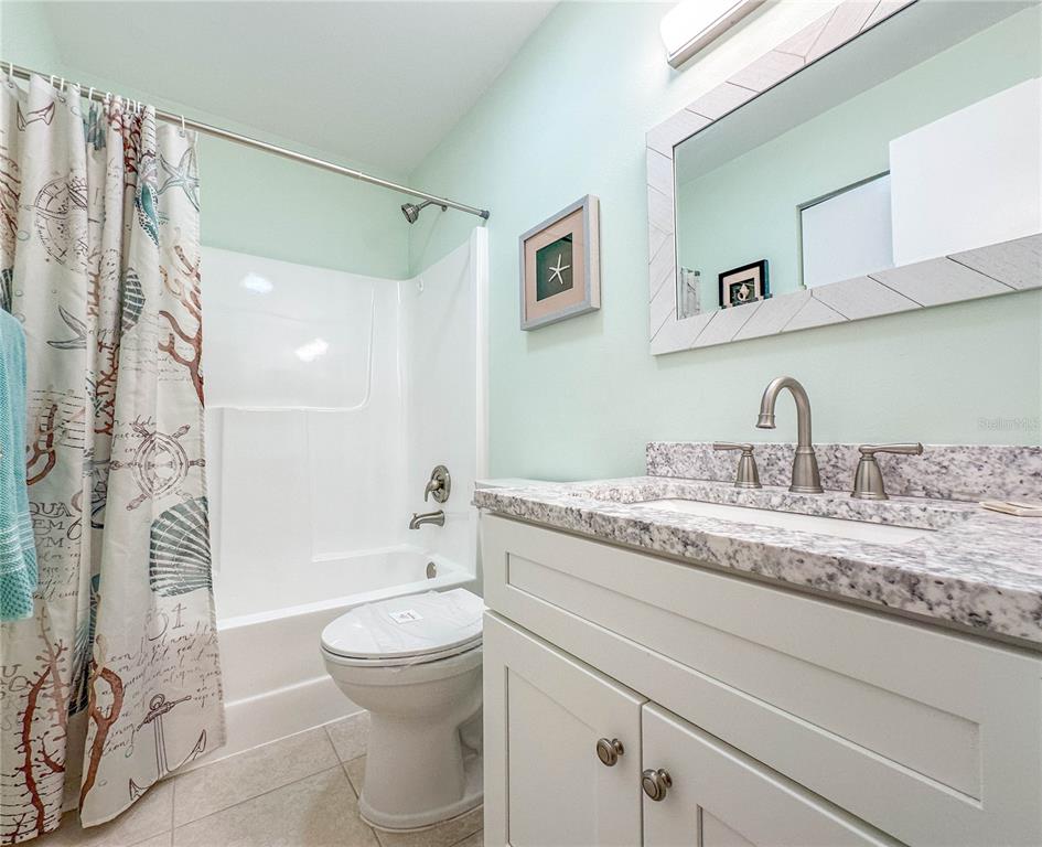 6800 Placida Road, Unit 268 Englewood, FL 34224 - Photo 17 of 33 a bathroom with a granite countertop sink a toilet and shower