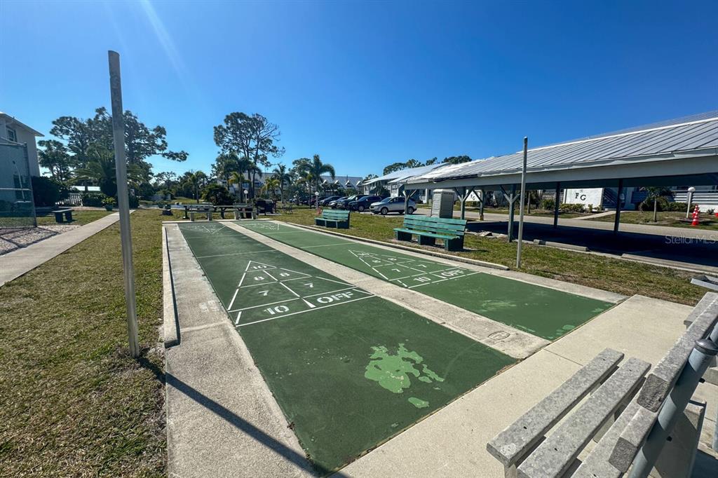 6800 Placida Road, Unit 268 Englewood, FL 34224 - Photo 27 of 33 a view of a swimming pool with a bench and trees in the background