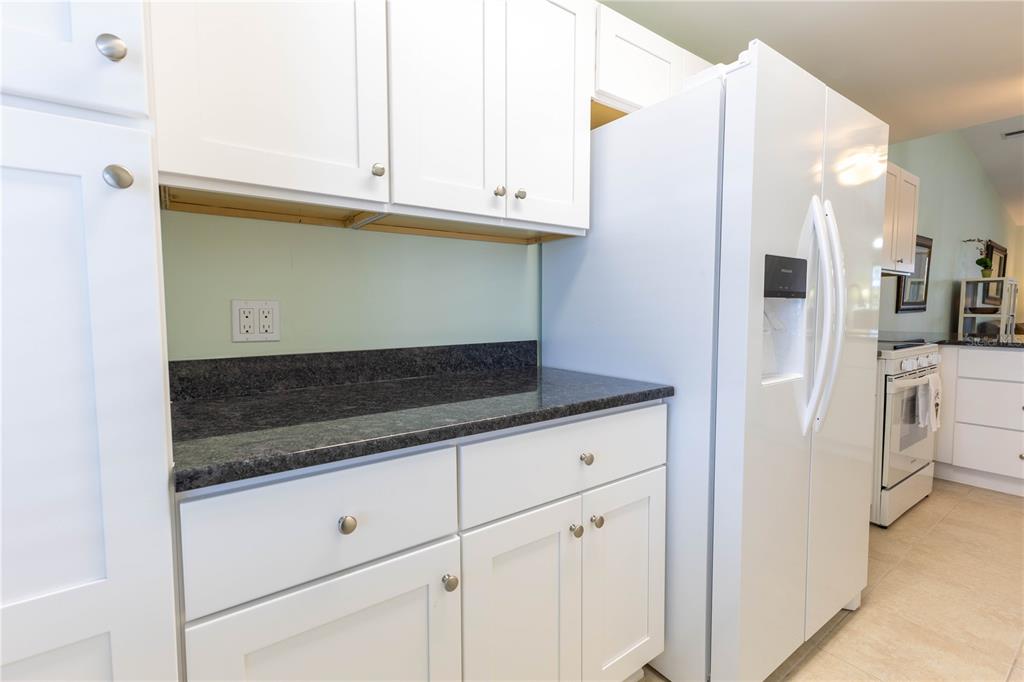 6800 Placida Road, Unit 268 Englewood, FL 34224 - Photo 6 of 33 a kitchen with granite countertop white cabinets and white appliances