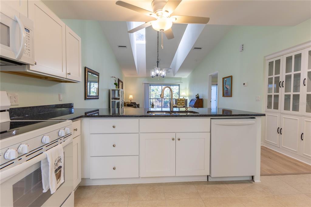 6800 Placida Road, Unit 268 Englewood, FL 34224 - Photo 9 of 33 a kitchen with white cabinets and chandelier