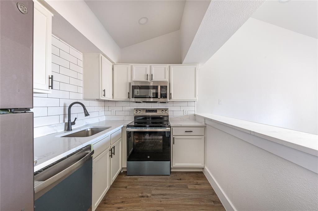6108 Abrams Road, Unit 126 Dallas, TX 75231 - Photo 4 of 11 a kitchen with white cabinets stainless steel appliances and a sink