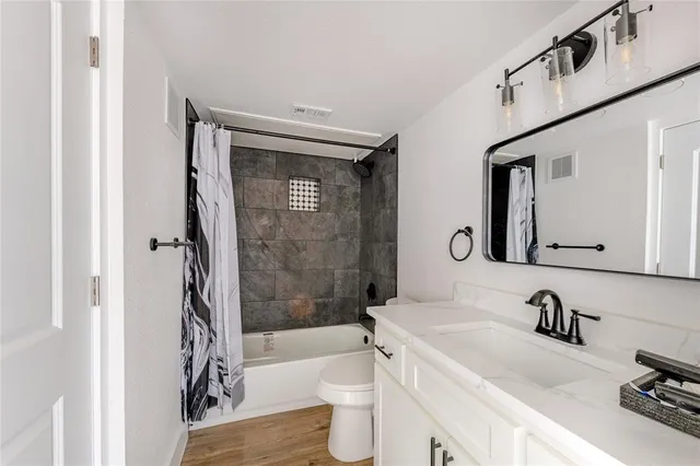a bathroom with a granite countertop sink toilet and shower