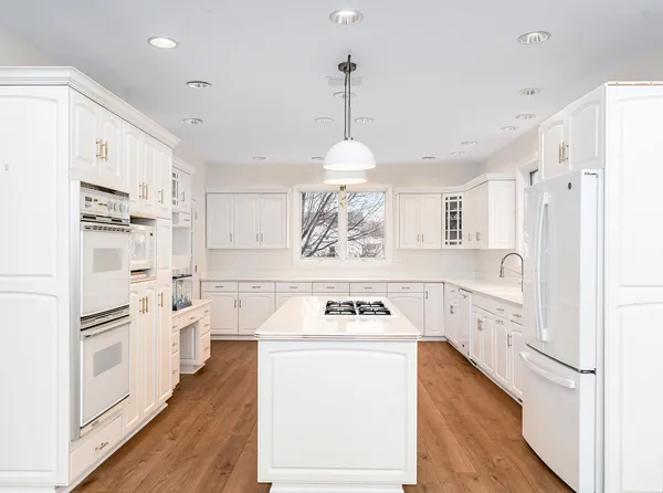 a kitchen with white cabinets and white appliances