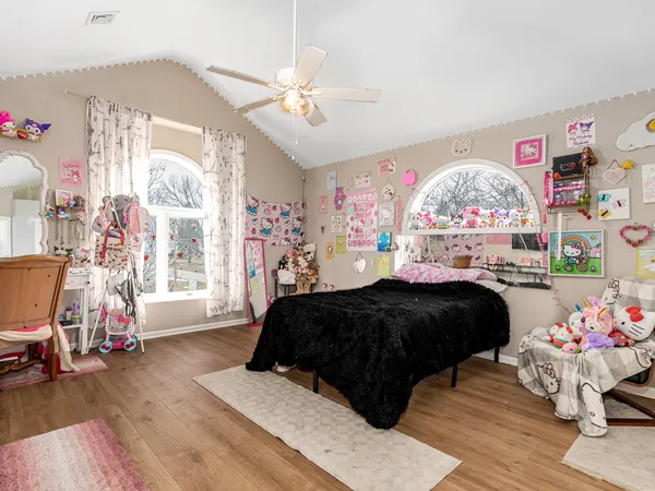 a bedroom with a bed mirror and a window