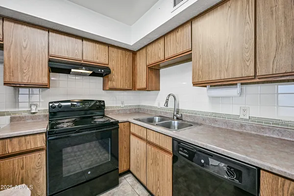 a kitchen with a sink stove top oven and cabinets