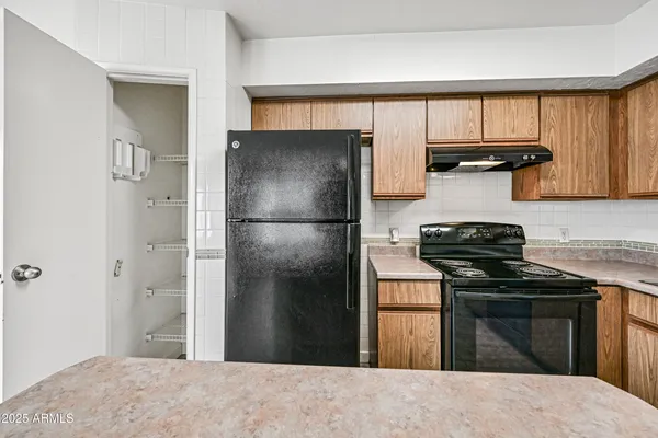 a kitchen with a refrigerator and a stove top oven