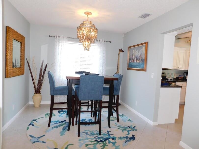 1150 Emerald Lane Singer Island, FL 33404 - Photo 7 of 25 a view of a dining room with furniture and chandelier