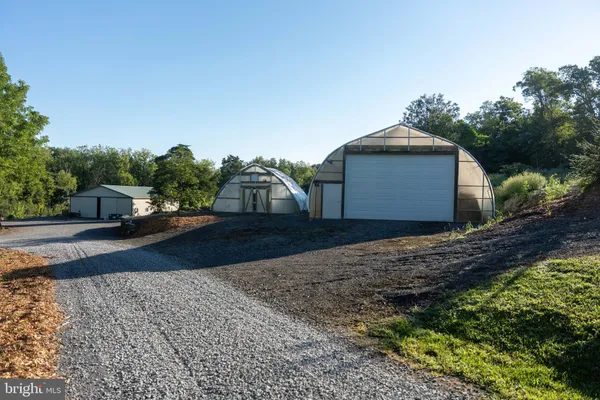 an aerial view of residential houses with outdoor space and trees