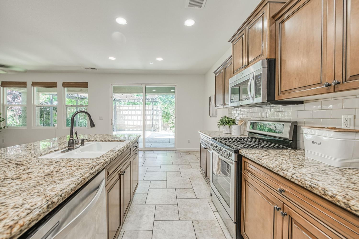 3521 Buckingham Avenue Clovis, CA 93619 - Photo 15 of 33 a kitchen with granite countertop stainless steel appliances a sink stove and cabinets