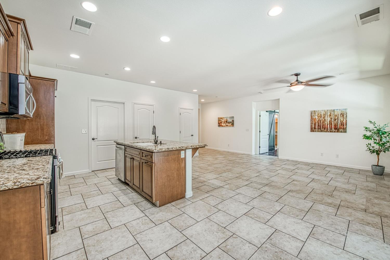 3521 Buckingham Avenue Clovis, CA 93619 - Photo 16 of 33 a kitchen with stainless steel appliances granite countertop a stove and a sink