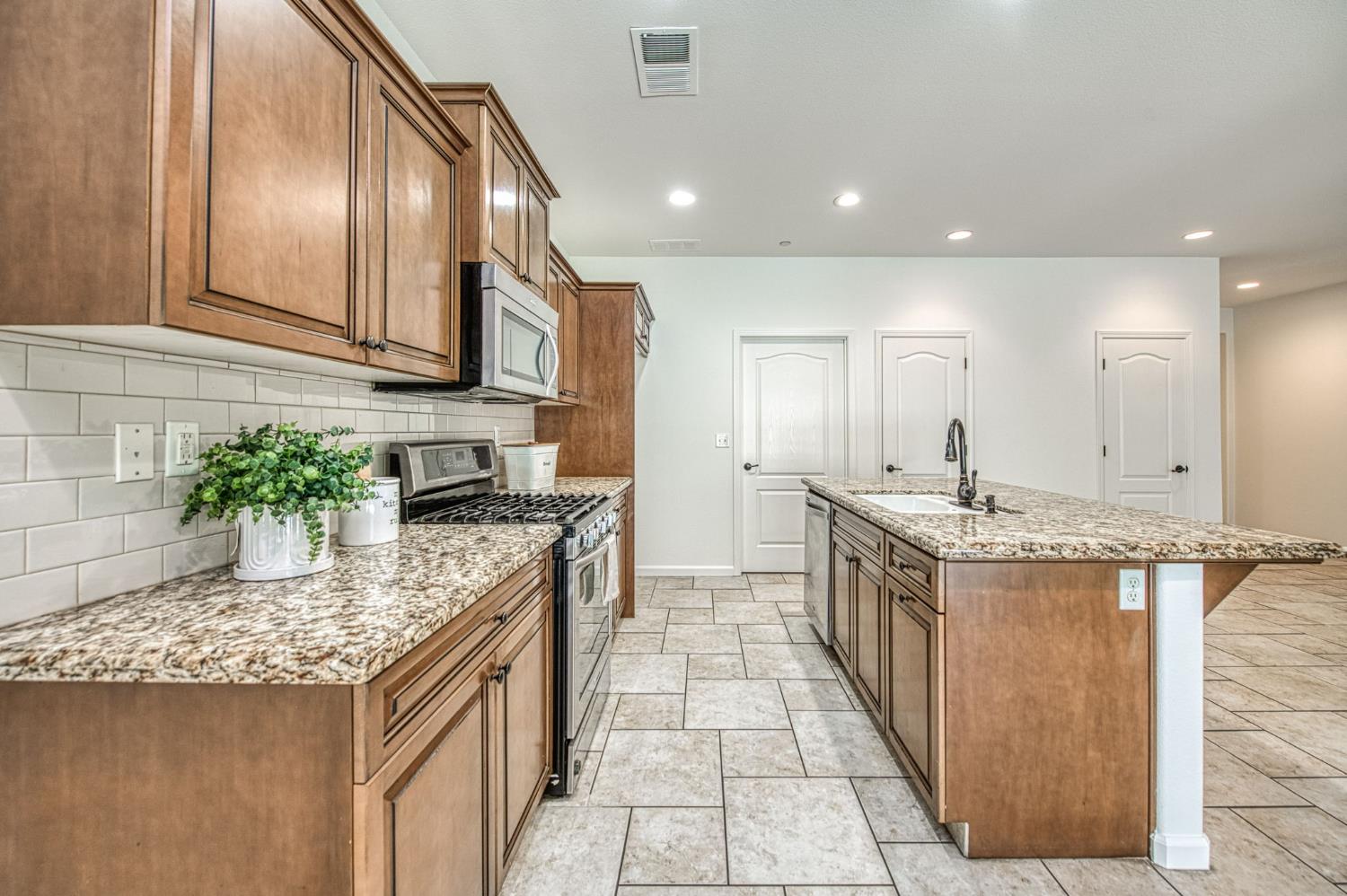 3521 Buckingham Avenue Clovis, CA 93619 - Photo 17 of 33 a kitchen with a sink stove and cabinets