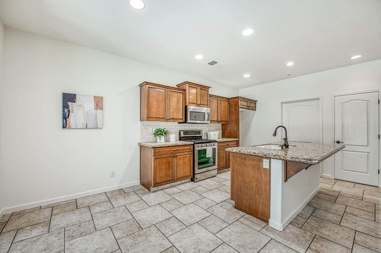 3521 Buckingham Avenue Clovis, CA 93619 - Photo 18 of 33 a kitchen with stainless steel appliances granite countertop a sink and cabinets
