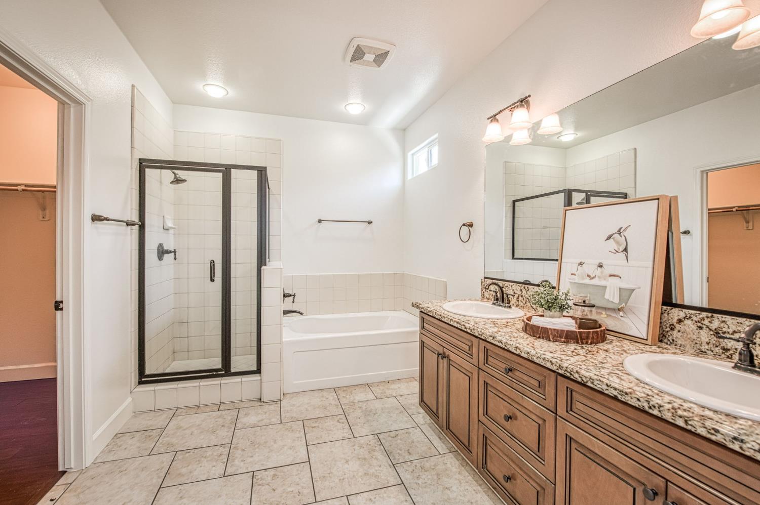 3521 Buckingham Avenue Clovis, CA 93619 - Photo 25 of 33 a spacious bathroom with a granite countertop double vanity sink a mirror and a bathtub