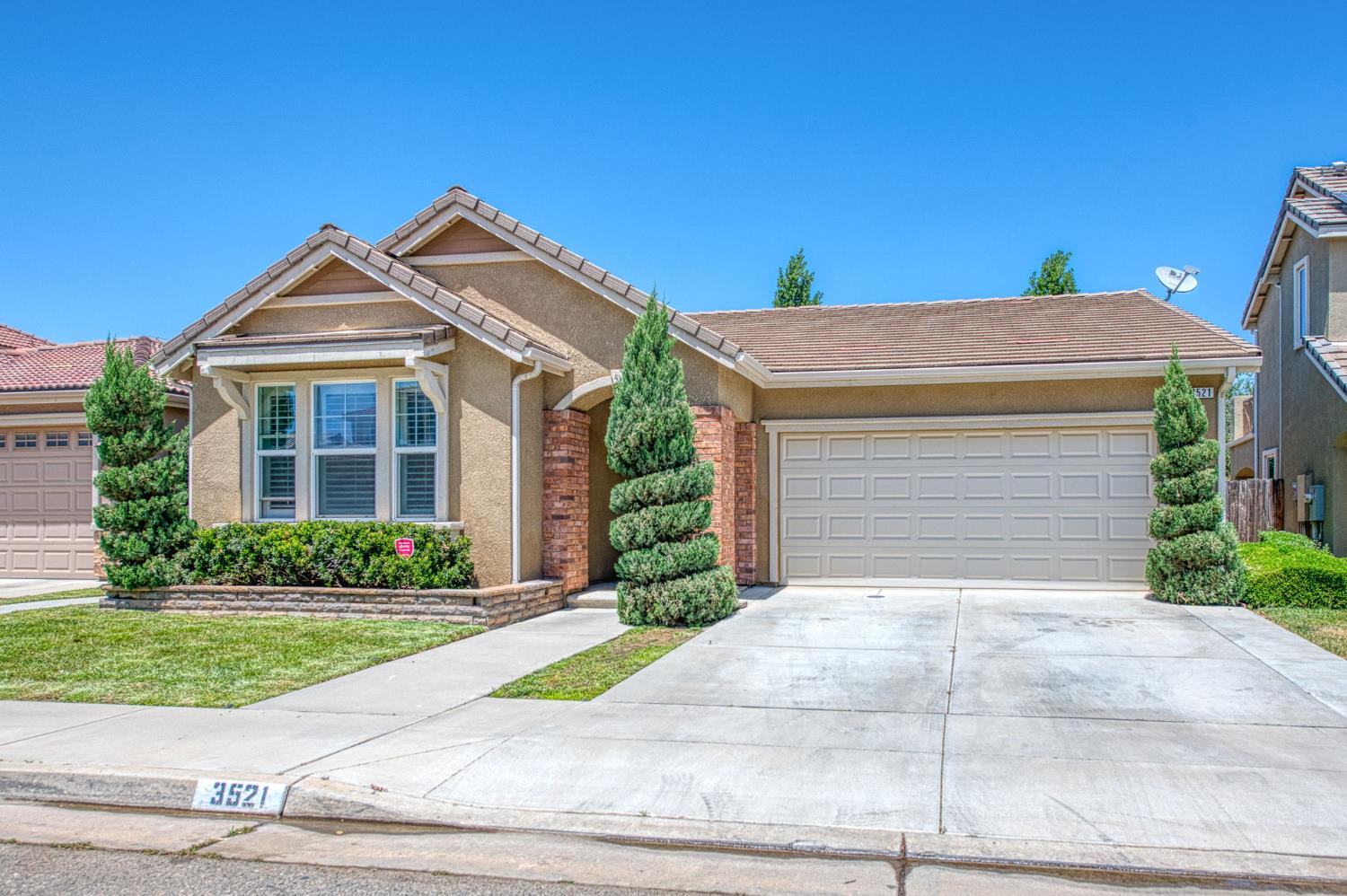 3521 Buckingham Avenue Clovis, CA 93619 - Photo 3 of 33 a front view of a house with a yard and garage