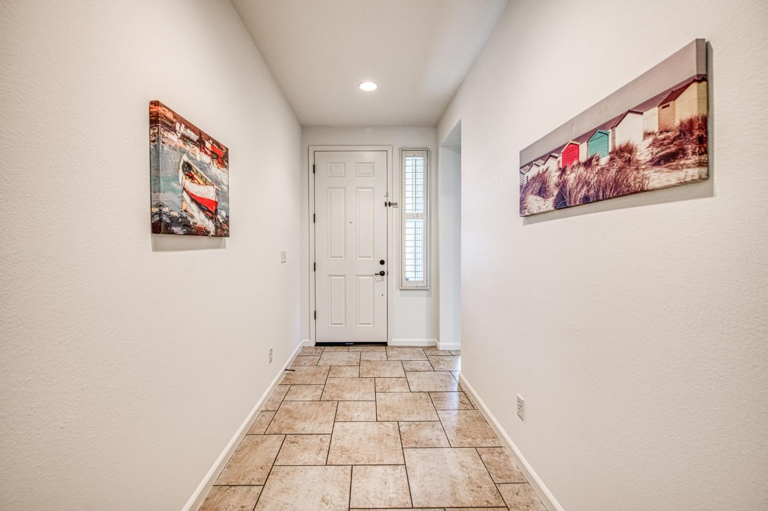 3521 Buckingham Avenue Clovis, CA 93619 - Photo 5 of 33 a view of a hallway with paintings on the wall