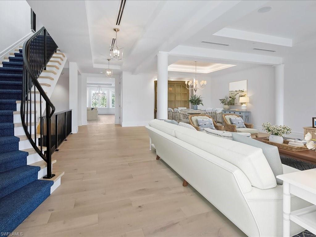 745 12th Avenue South, Unit 102 Naples, FL 34102 - Photo 11 of 50 a large bedroom with wooden floor and furniture