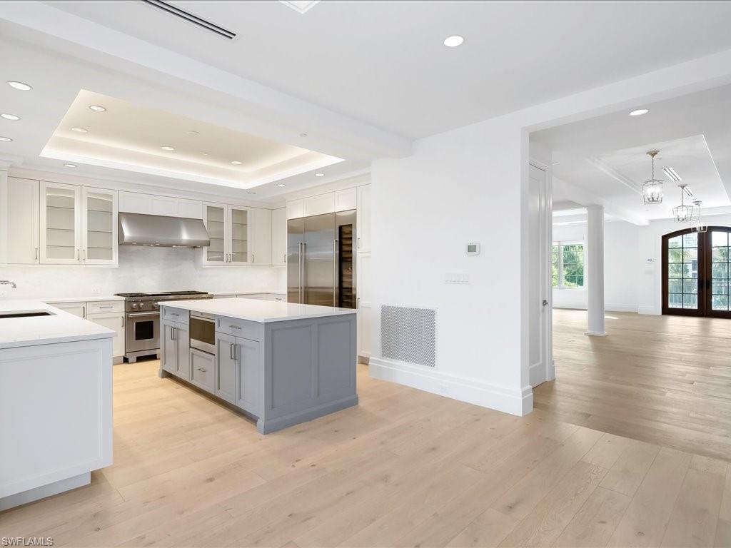 745 12th Avenue South, Unit 102 Naples, FL 34102 - Photo 15 of 50 a large kitchen with stainless steel appliances granite countertop a stove top oven a sink a refrigerator and white cabinets