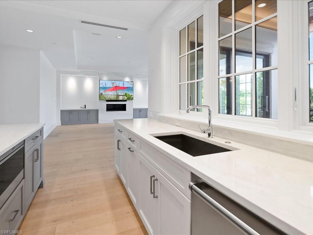 745 12th Avenue South, Unit 102 Naples, FL 34102 - Photo 18 of 50 a kitchen with a sink and a stove top oven