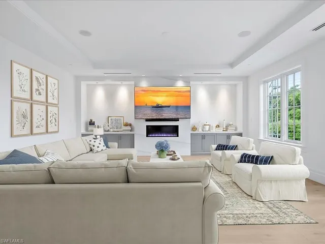 a living room with furniture a flat screen tv and a large window