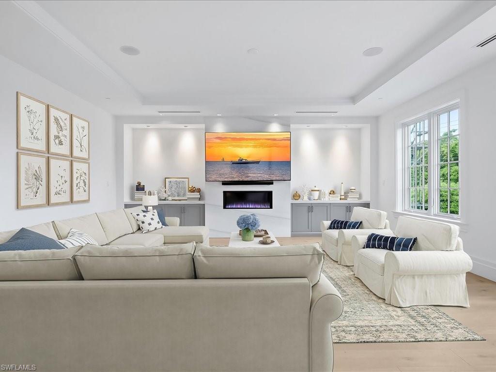 745 12th Avenue South, Unit 102 Naples, FL 34102 - Photo 19 of 50 a living room with furniture a flat screen tv and a large window