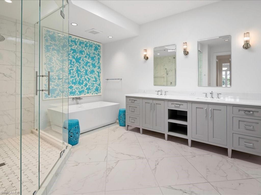 745 12th Avenue South, Unit 102 Naples, FL 34102 - Photo 26 of 50 a bathroom with a tub sink and mirror