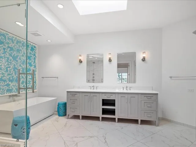 a spacious bathroom with a tub sink and mirror