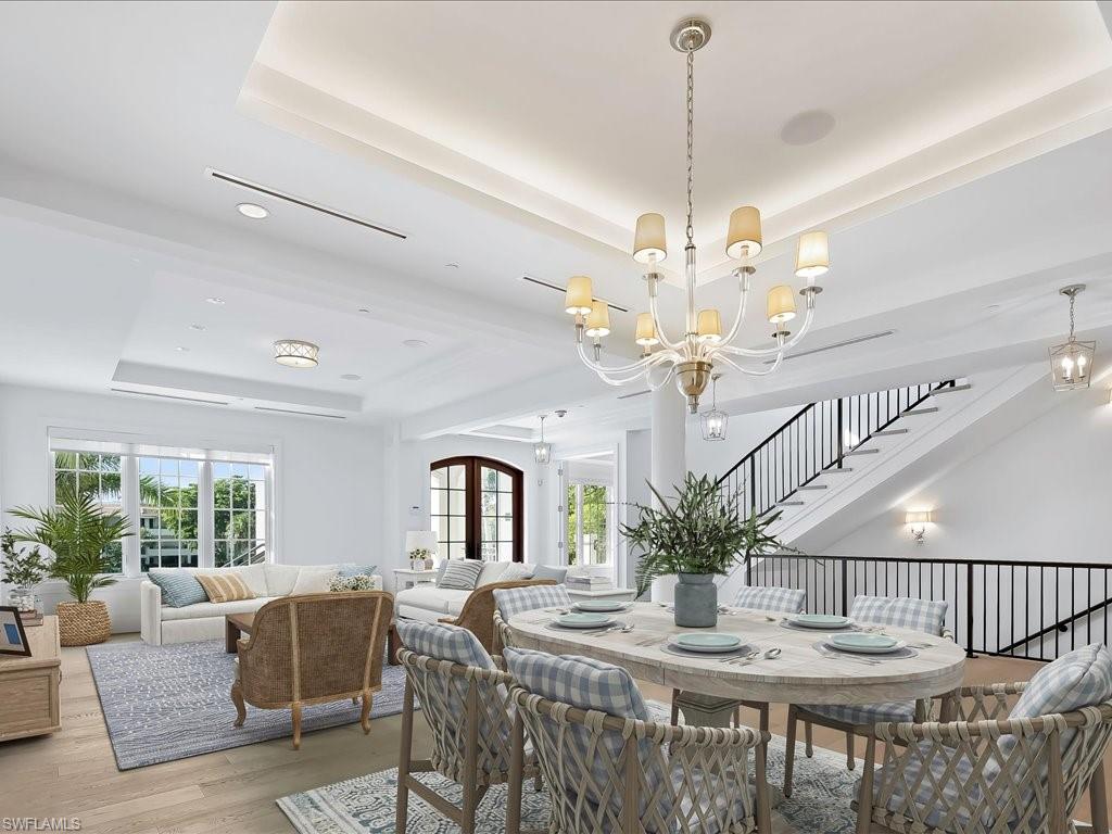 745 12th Avenue South, Unit 102 Naples, FL 34102 - Photo 9 of 50 a view of a dining room with furniture a chandelier and large windows