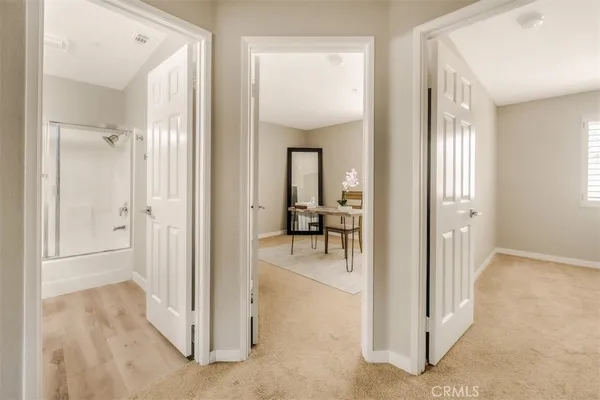 wooden view of a hallway with a livingroom and a bathroom