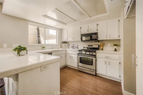 a kitchen with white cabinets and appliances