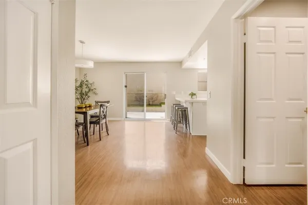 a hallway with wooden floor table and chairs