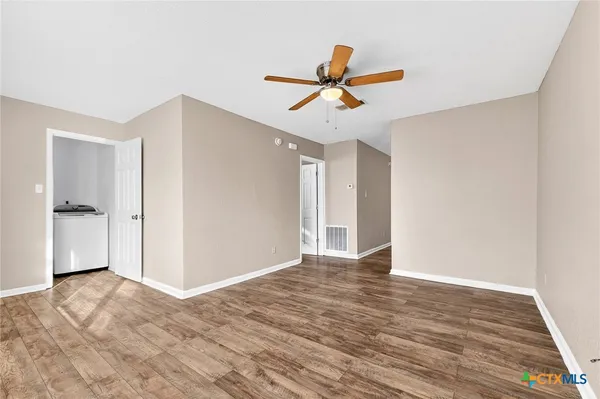 a view of room with wooden floor and ceiling fan
