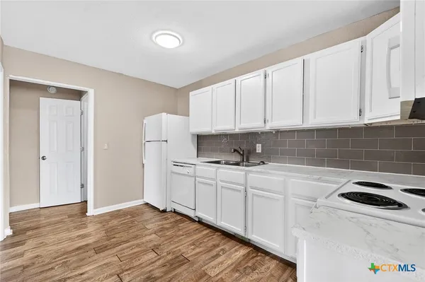 a kitchen with stainless steel appliances white cabinets and a sink