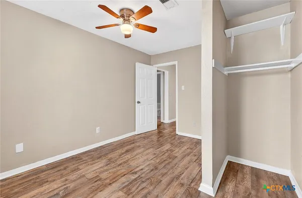 a view of an empty room with wooden floor