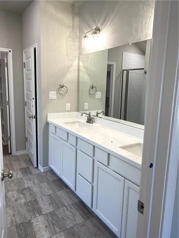 a bathroom with a double vanity sink and mirror