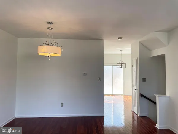 a view of a room with wooden floor staircase and a kitchen space