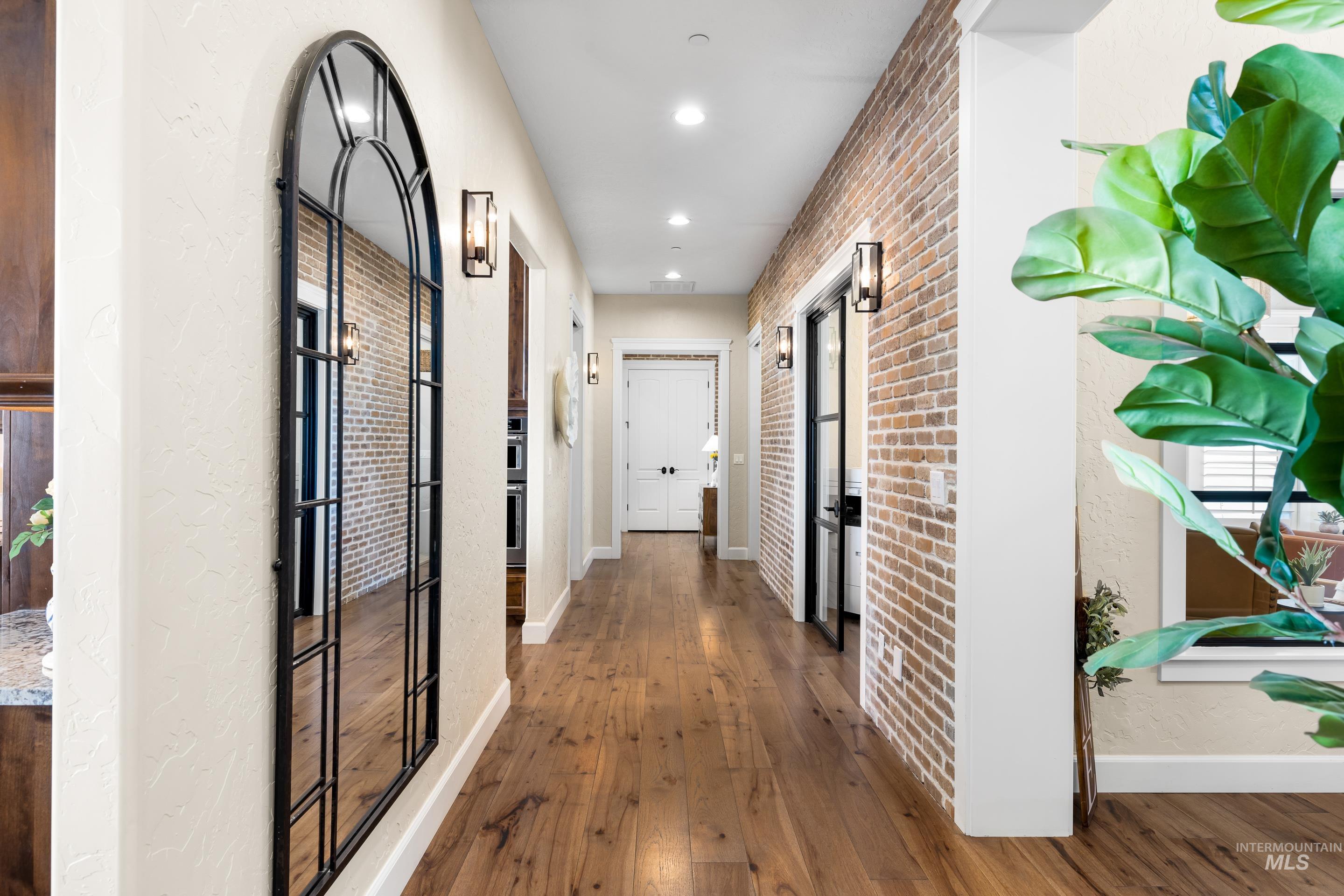 9819 Foothill Road Middleton, ID 83644 - Photo 11 of 49 Hallway featuring hardwood / wood-style floors, recessed lighting, and brick wall