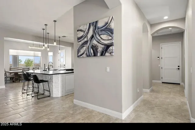a kitchen with stainless steel appliances kitchen island a table and chairs in it