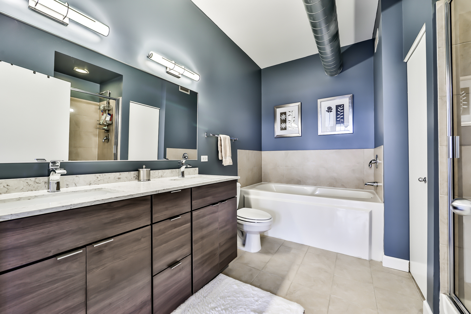 1200 West Monroe Street, Unit 801 Chicago, IL 60607 - Photo 16 of 26 a bathroom with a toilet a sink a mirror and a bathtub