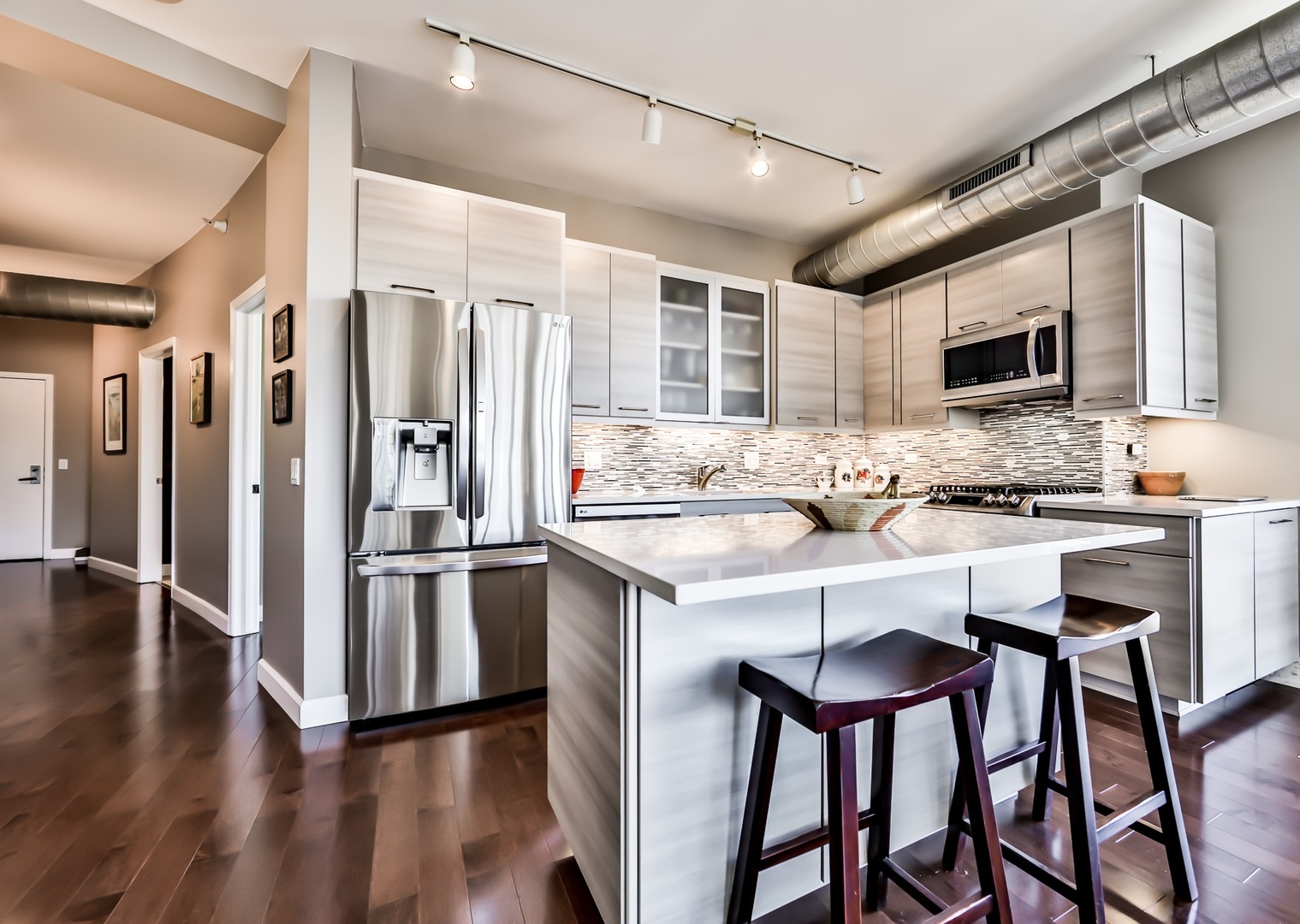 1200 West Monroe Street, Unit 801 Chicago, IL 60607 - Photo 10 of 26 a kitchen with stainless steel appliances kitchen island granite countertop a refrigerator and a stove top oven