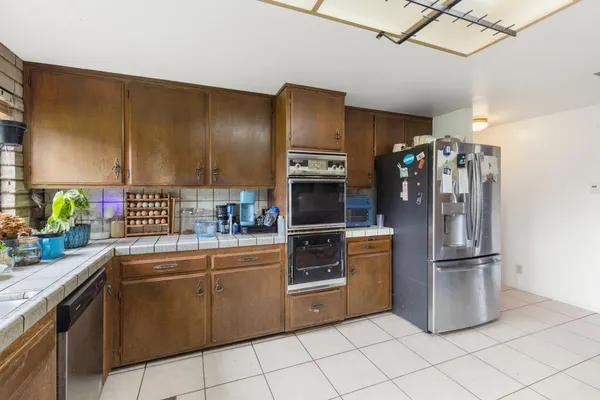 a kitchen with stainless steel appliances granite countertop a refrigerator and a sink