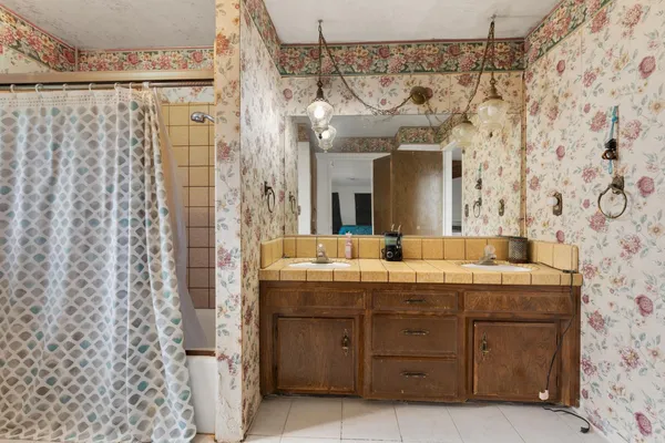 a bathroom with a granite countertop sink mirror and a shower