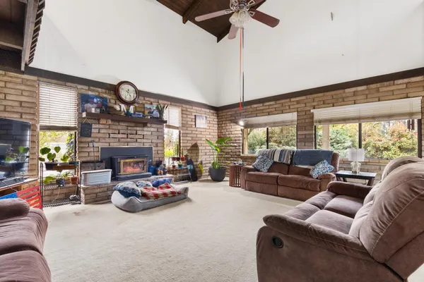 a living room with furniture fireplace and a large window
