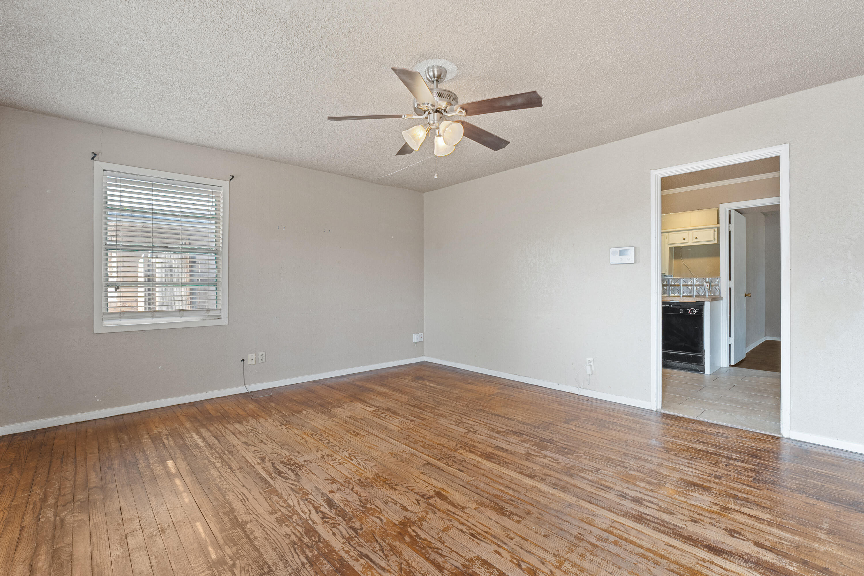 3602 31st Street Lubbock, TX 79410 - Photo 4 of 15 wooden floor in an empty room with a window