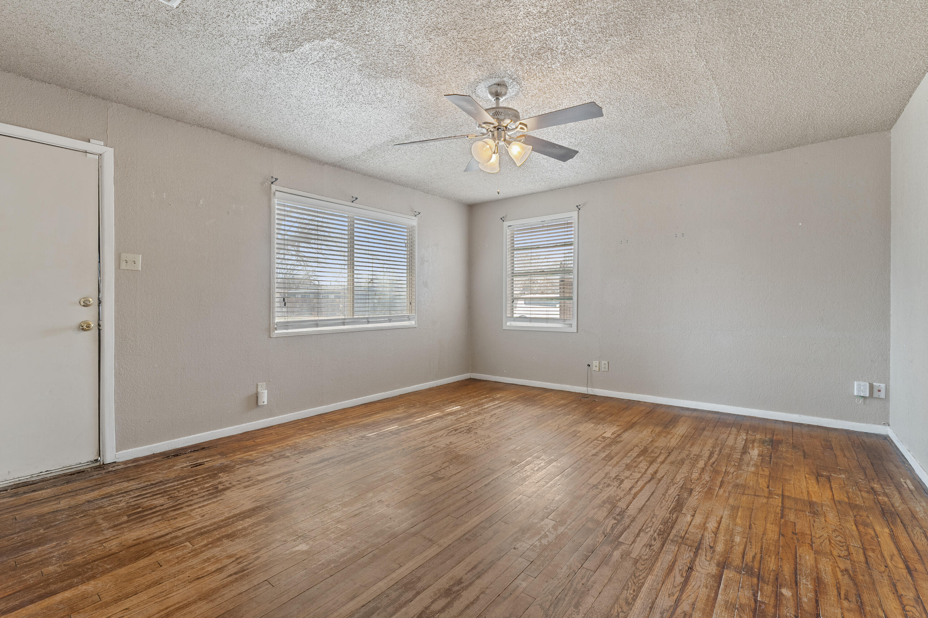 3602 31st Street Lubbock, TX 79410 - Photo 5 of 15 a view of an empty room with wooden floor and a window