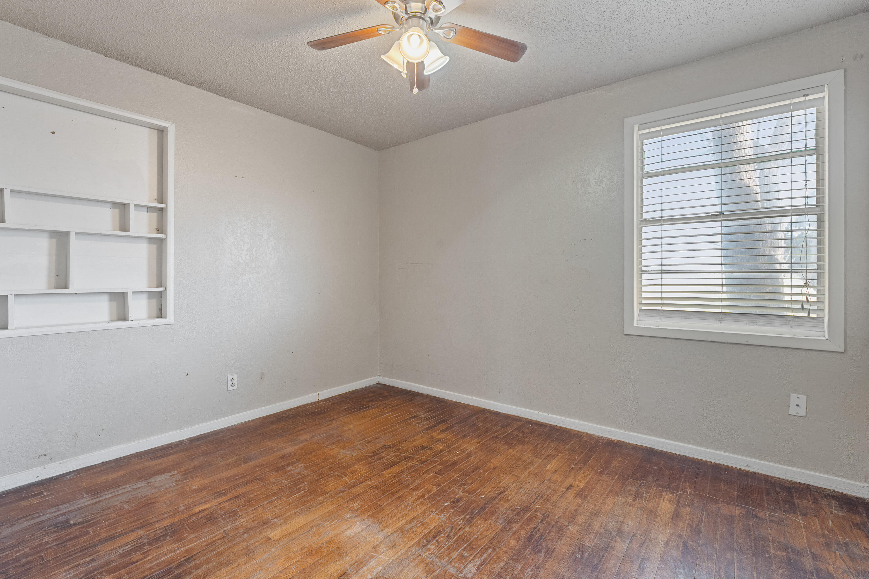3602 31st Street Lubbock, TX 79410 - Photo 10 of 15 wooden floor in an empty room with a window