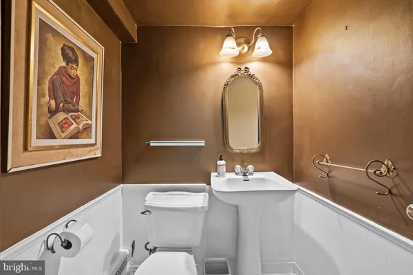 a bathroom with a sink vanity mirror and toilet